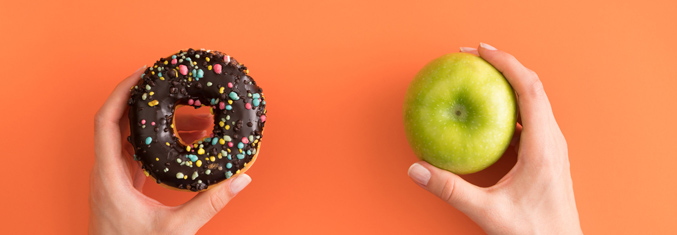 Hand holding donut and apple