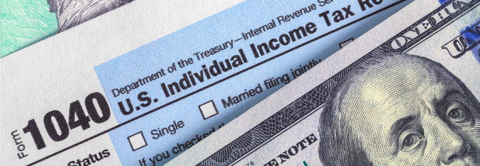 Charitable giving paradigm - Form 1040 laying over a 100 dollar bill